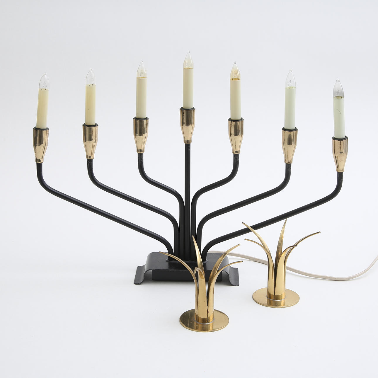 An electric candlestick and brass candlesticks, 20th century.
