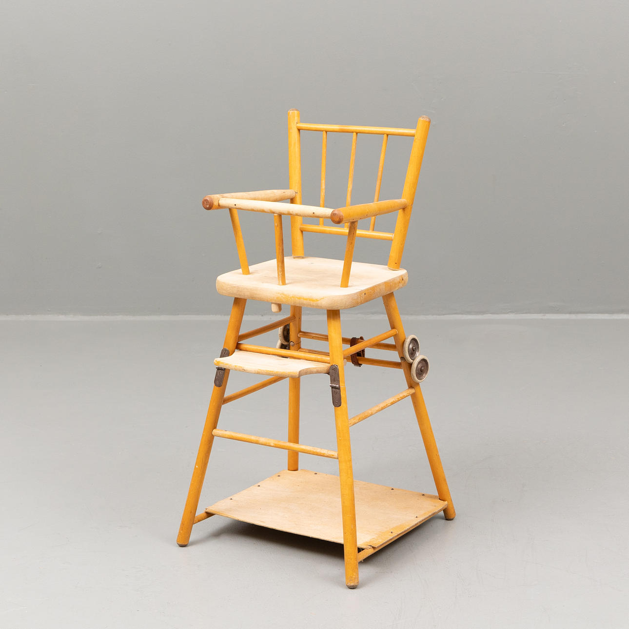 A mid 20th century foldable birch highchair.