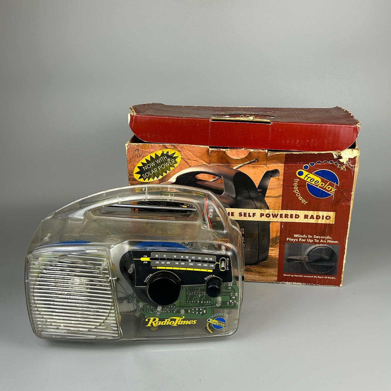 A BOXED PERSPEX WIND UP RADIO.