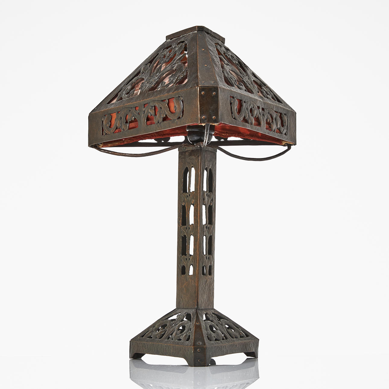 A table lamp, hammered copper, 1920s, late Art Nouveau, triangular shape, openwork decoration of leaf ornaments.
