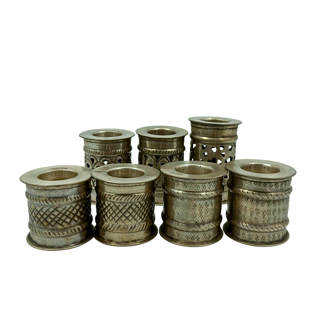SEVEN ORIENTAL-STYLE METAL CANDLE HOLDERS.
