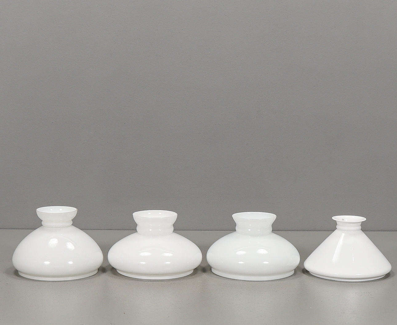 Four glass lamp cups, 20th century.