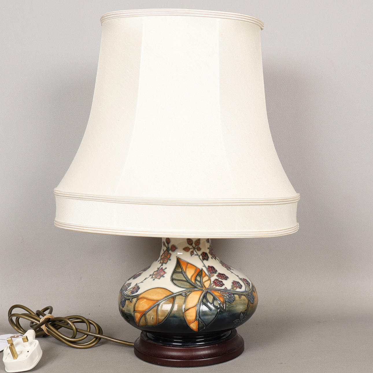 A MOORCROFT POTTERY BRAMBLE PATTERNED TABLE LAMP AND SHADE.