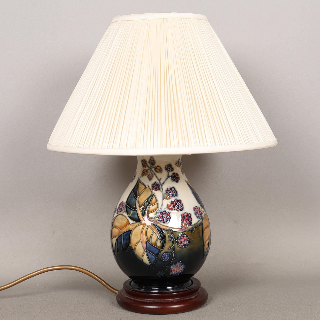 A MOORCROFT POTTERY BRAMBLE PATTERN TABLE LAMP AND SHADE.