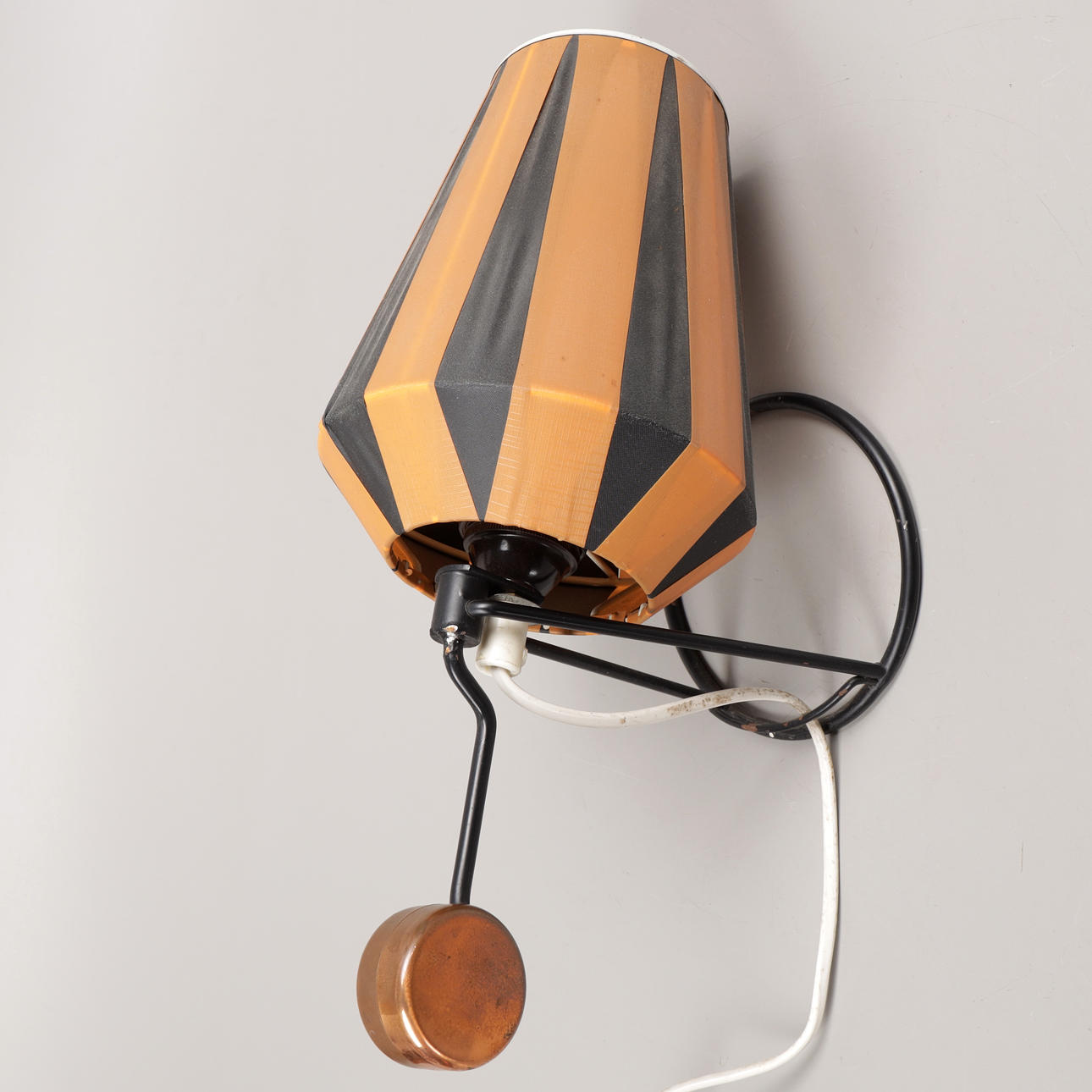 A 1950's wall lamp with plastic strap.