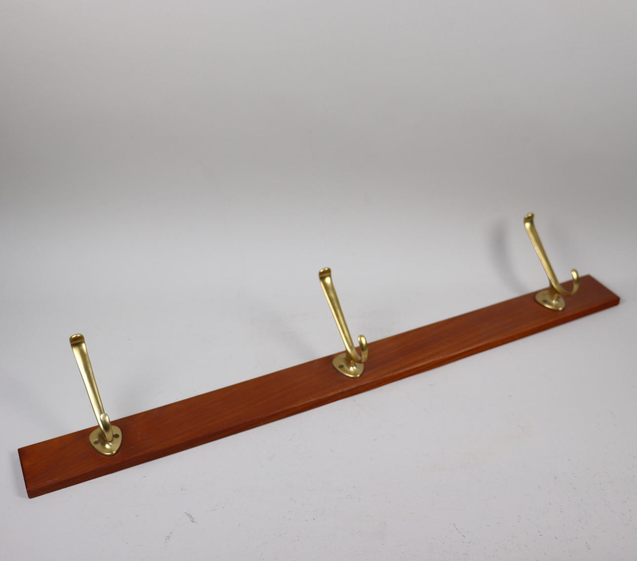 TEAK AND BRASS CLOTHES HANGER.