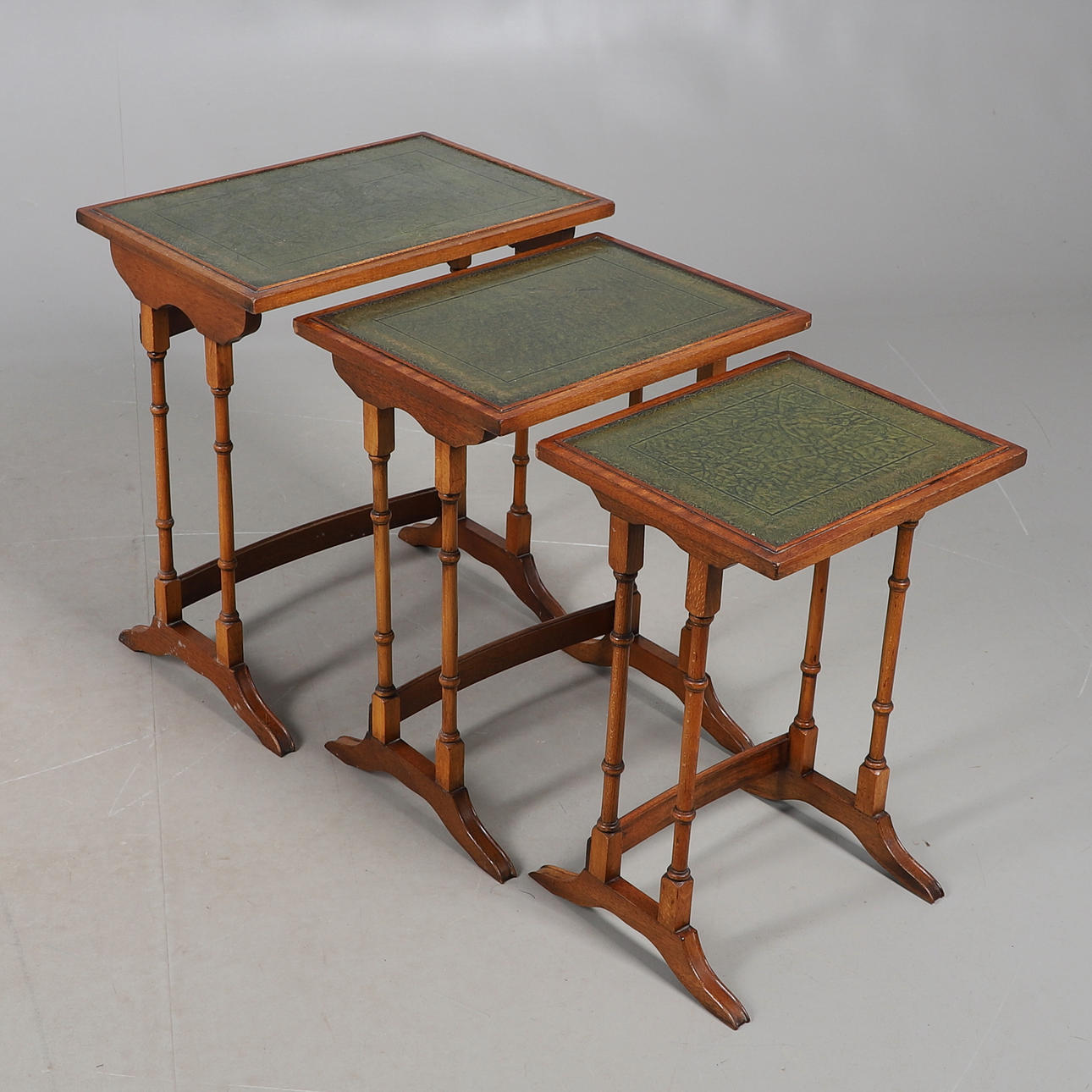 EDWARDIAN LEATHER-TOPPED MAHOGANY NESTING TABLES.