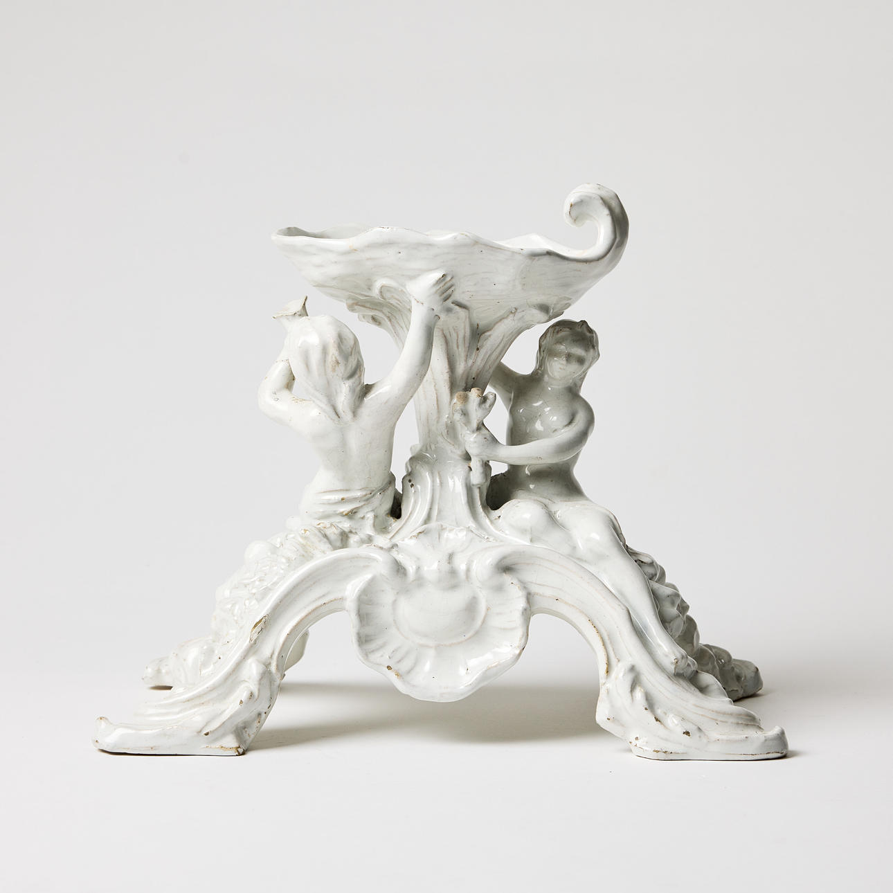 RÖRSTRAND (establishment. 1726), table essay, faience, mid 18th century, rococo, white glaze, decor of najad and triton, bowl in the shape of a seashell with volute, pivoted legs with centre rocaille.