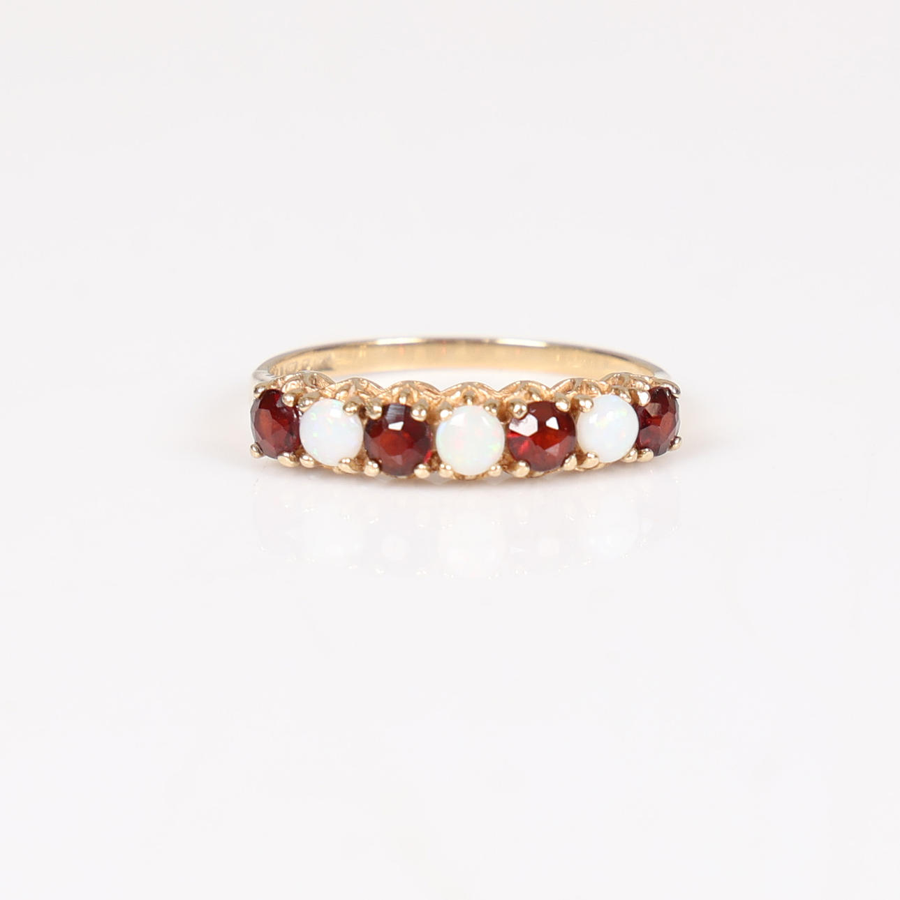 A 9 CARAT GOLD, OPAL AND GARNET RING.