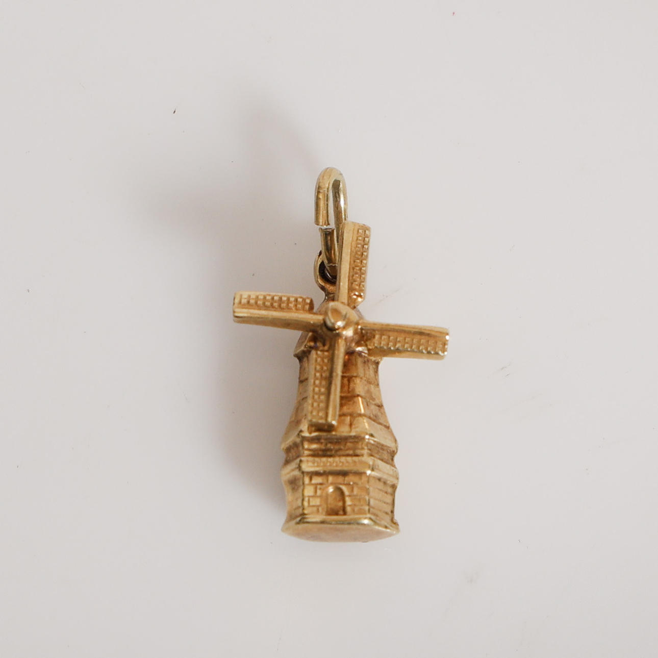 A 14 CARAT GOLD WINDMILL PENDANT/ CHARM.