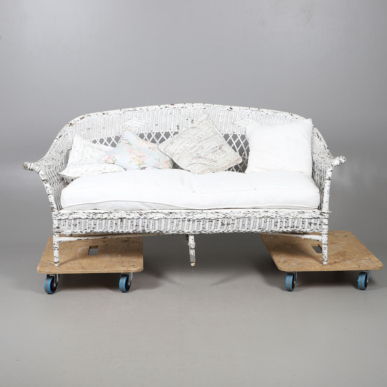 A LARGE PAINTED WICKER SOFA.