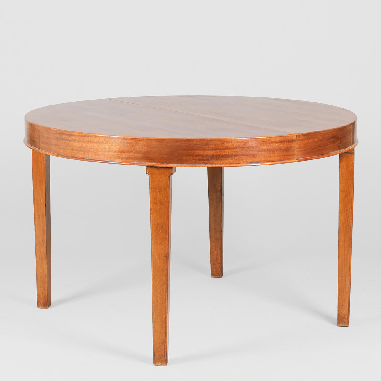 DANISH MASTER CARPENTER. Mahogany circular dining table with profiled edges, two additional plates, (1+2).