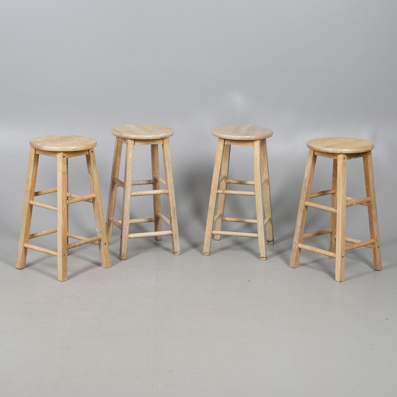 A SET OF FOUR STOOLS.