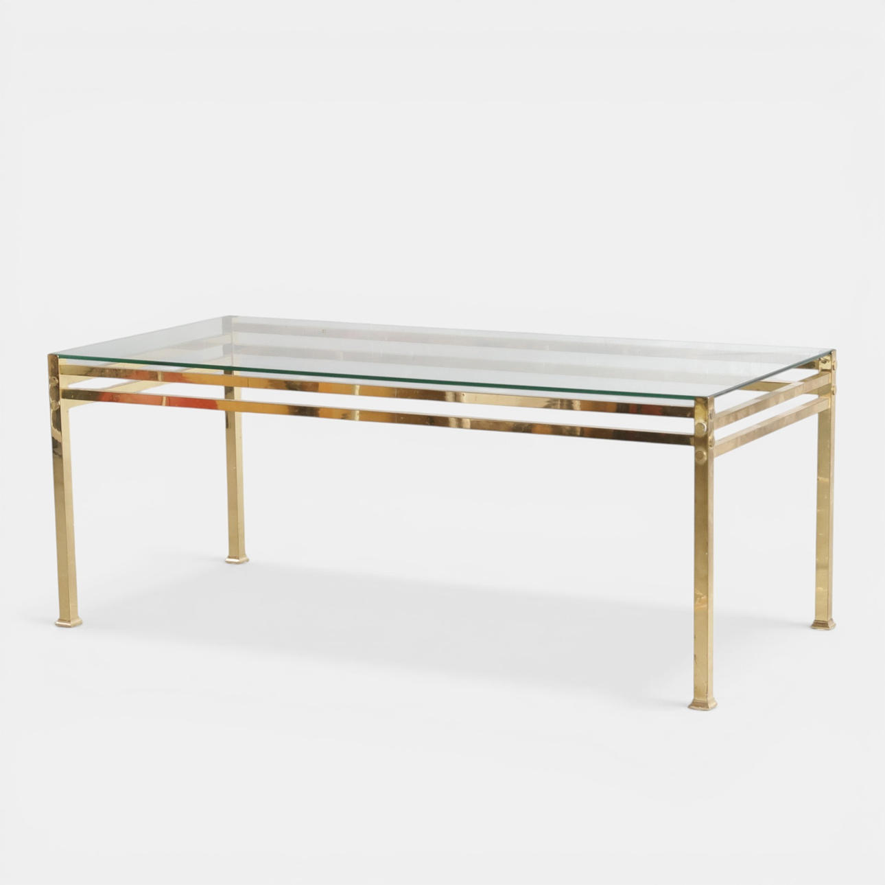 Rectangular coffee table with clear glass top, brass frame, Hollywood Regency style.