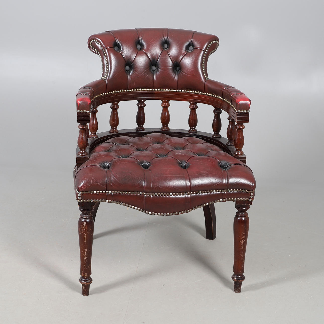 A REPRODUCTION LEATHER CAPTAINS CHAIR.