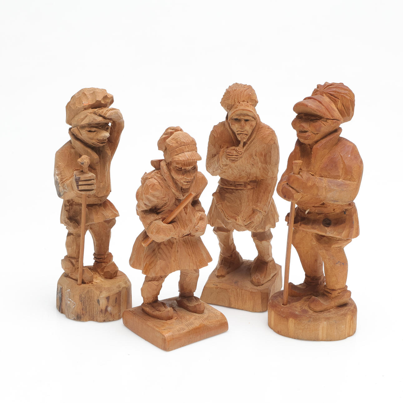 FOUR SAAMI SCULPTURES, carved wood, signed.