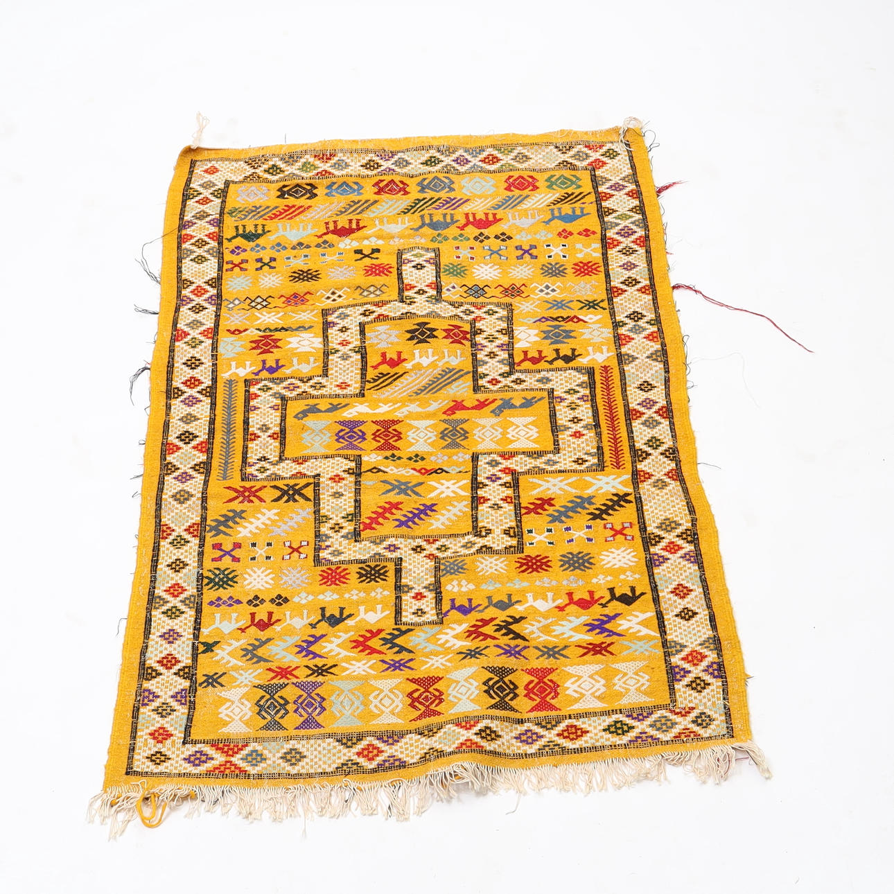 WOVEN RUG WITH EMBROIDERED DECOR.