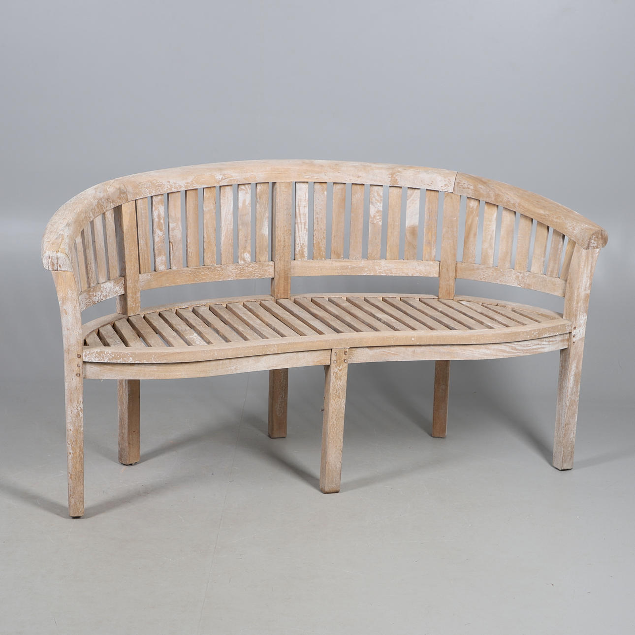 A TEAK BANANA GARDEN BENCH.