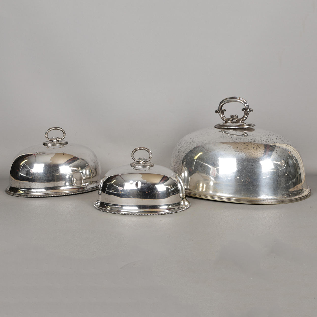 THREE SILVER PLATED MEAT PLATE COVERS (3).