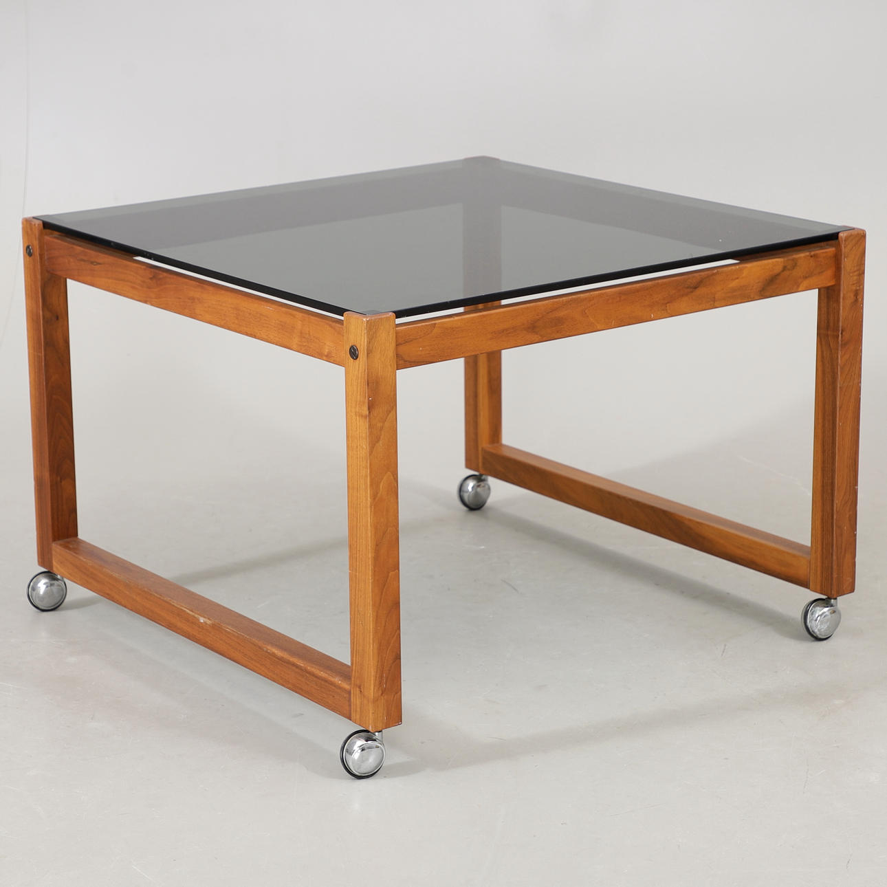 COFFEE TABLE ON WHEELS, walnut/glass, 1970s.