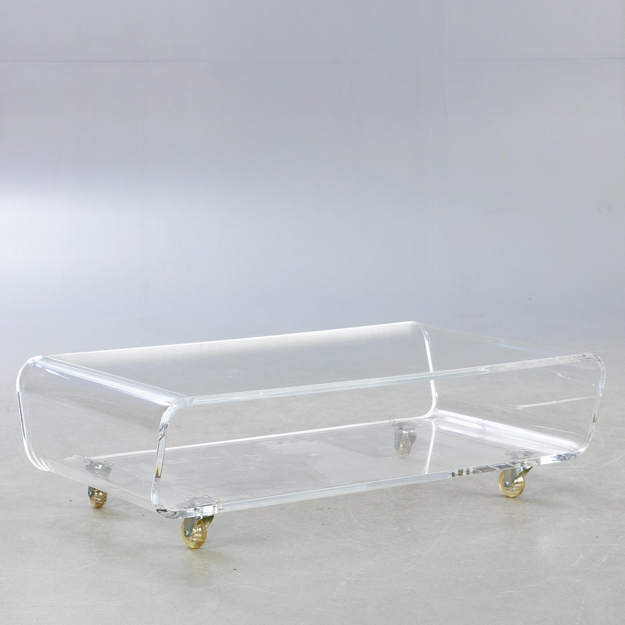 Low acrylic sofa table on wheels.