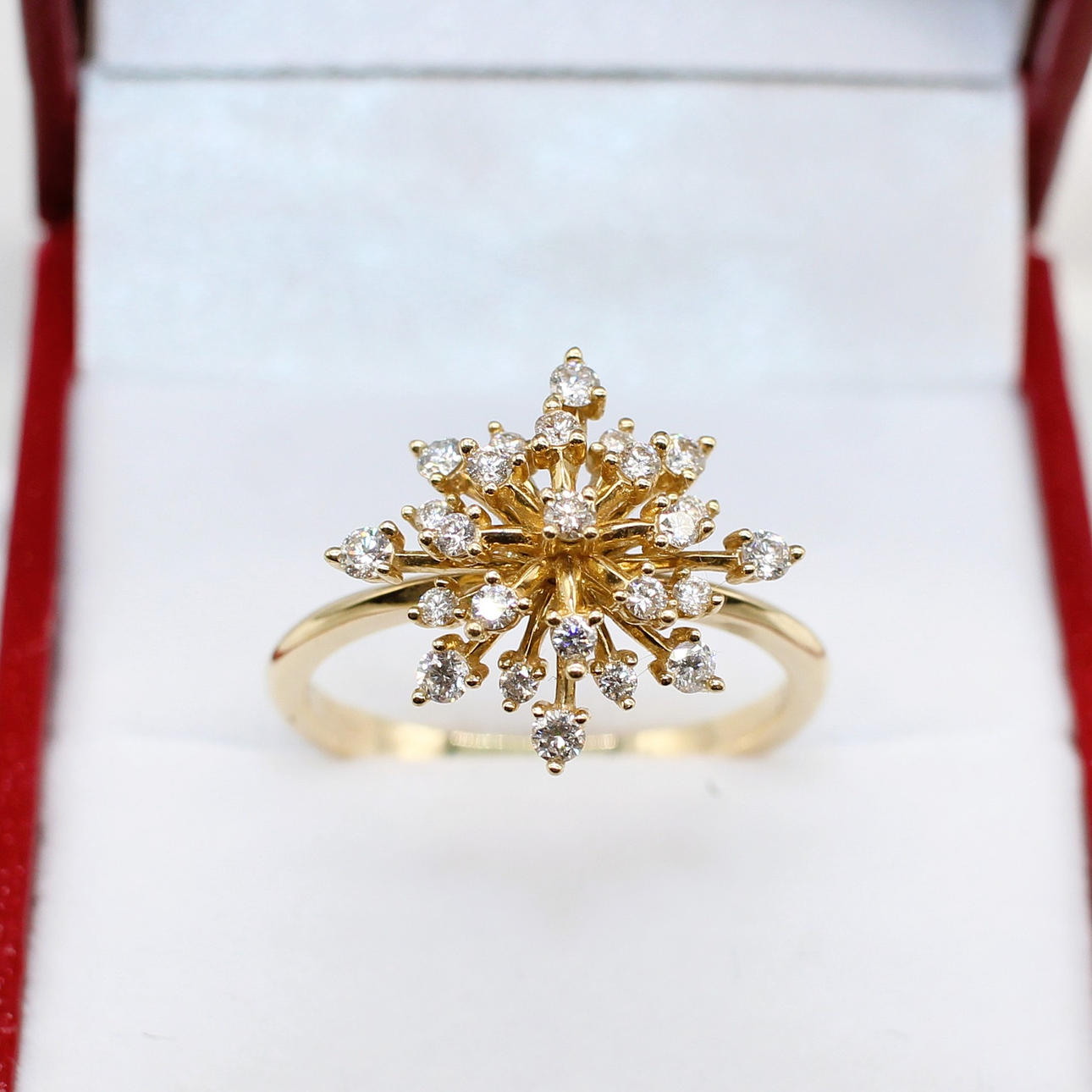 A DIAMOND STARBURST STYLE RING.