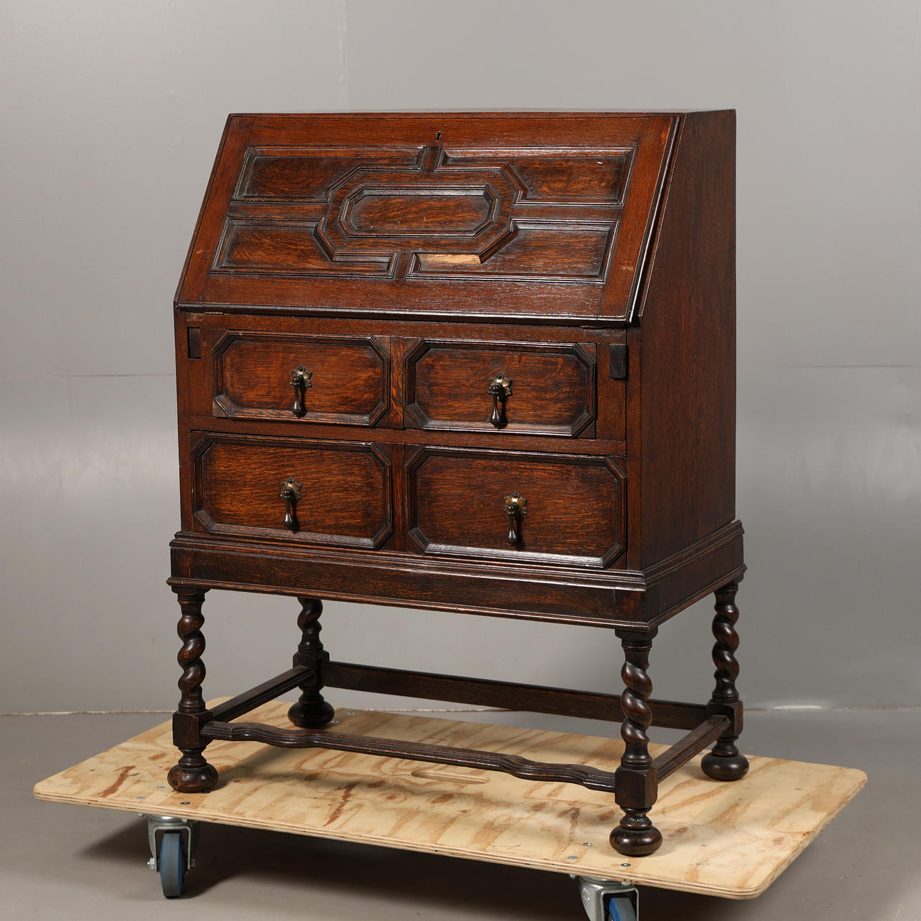 A CHARLES II STYLE OAK GEOMETRIC BUREAU.