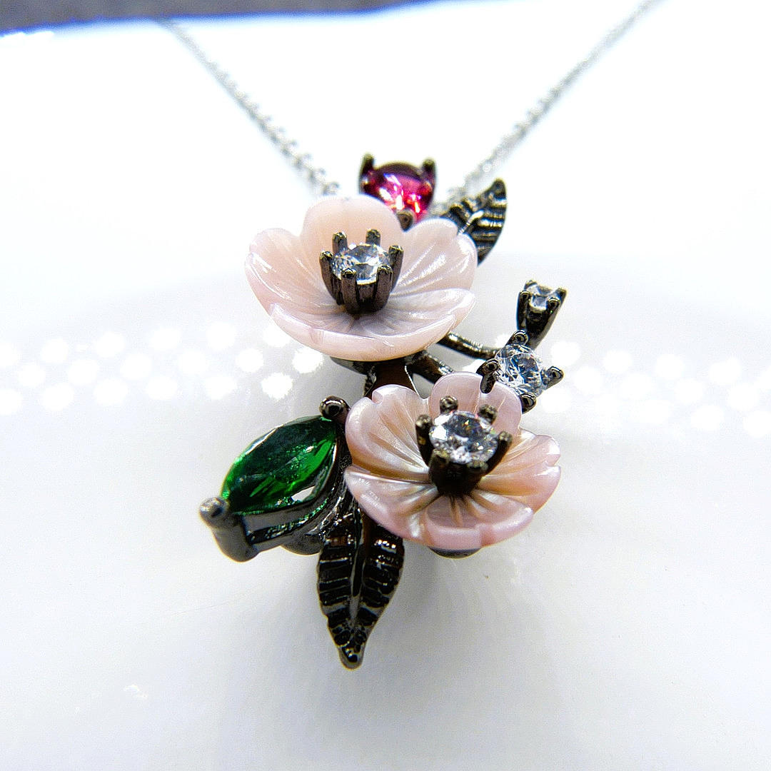 SILVER RHODIUM FLORAL PENDANT.