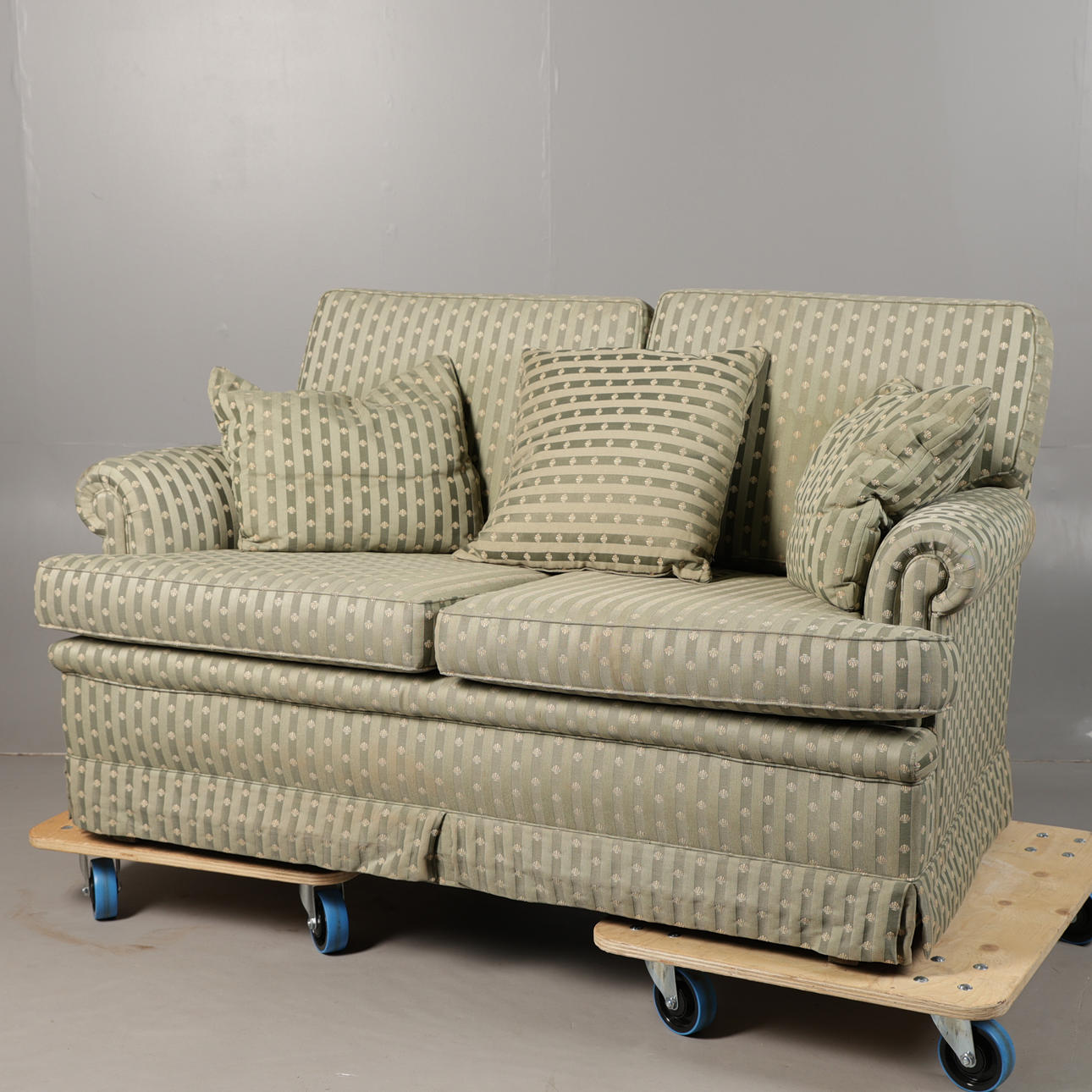 A 20TH CENTURY UPHOLSTERED TWO-SEATER SETTEE/SOFA.
