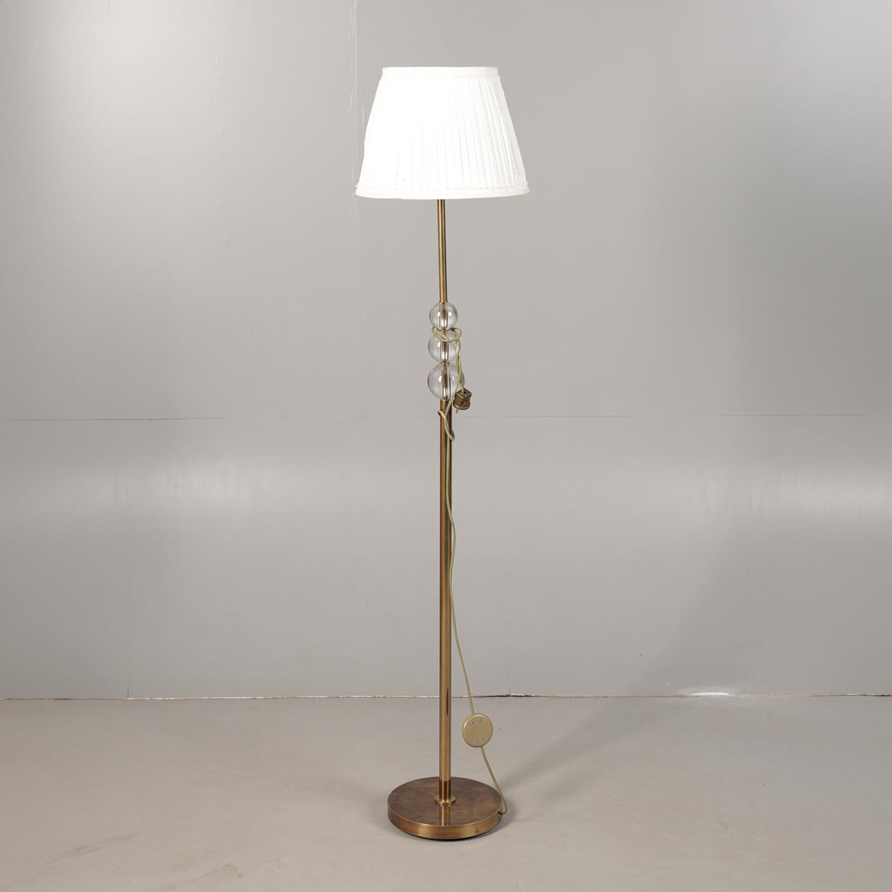 A BRASS AND GLASS STANDARD LAMP.