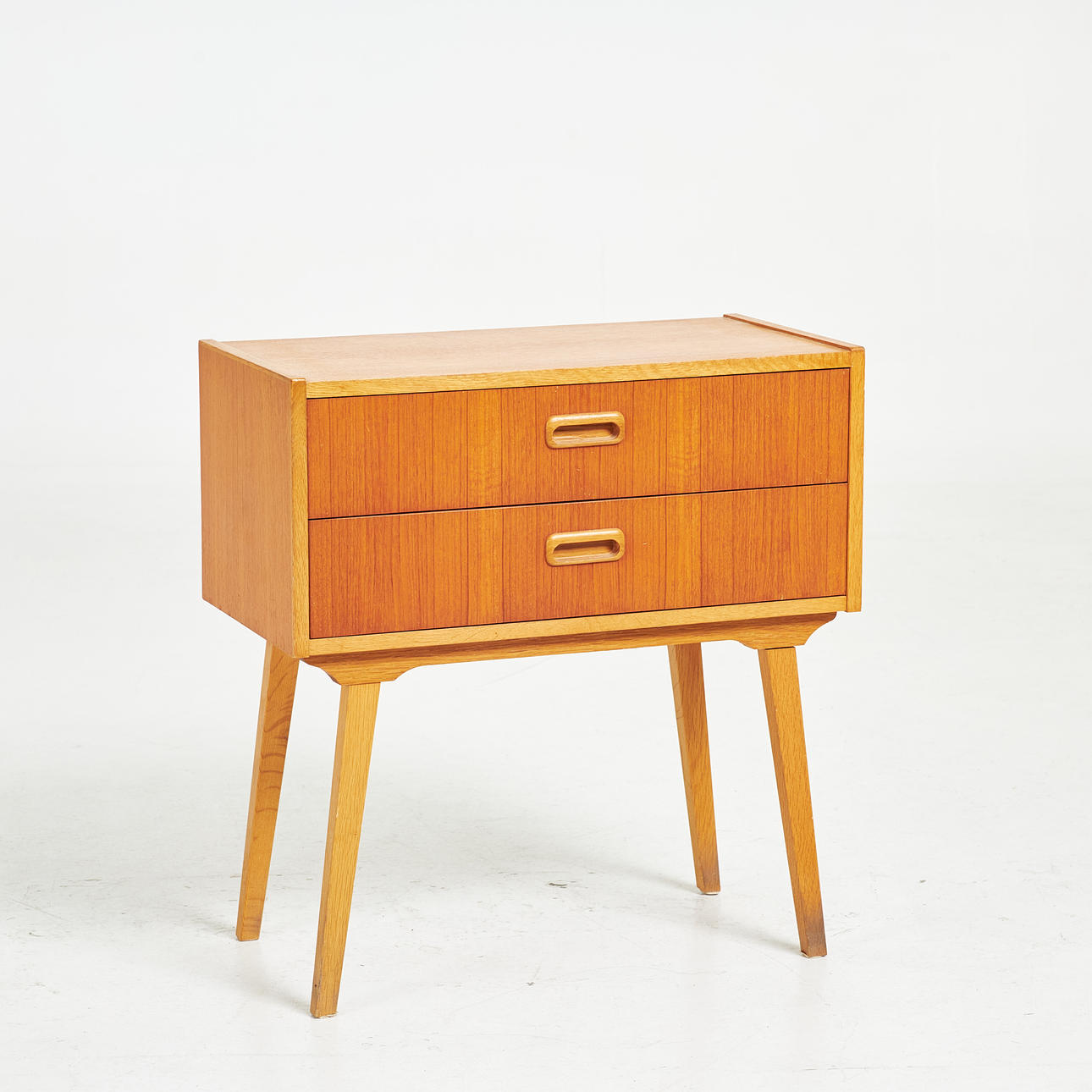A 1950s/60s bedside table, veneered in teak, two drawers.