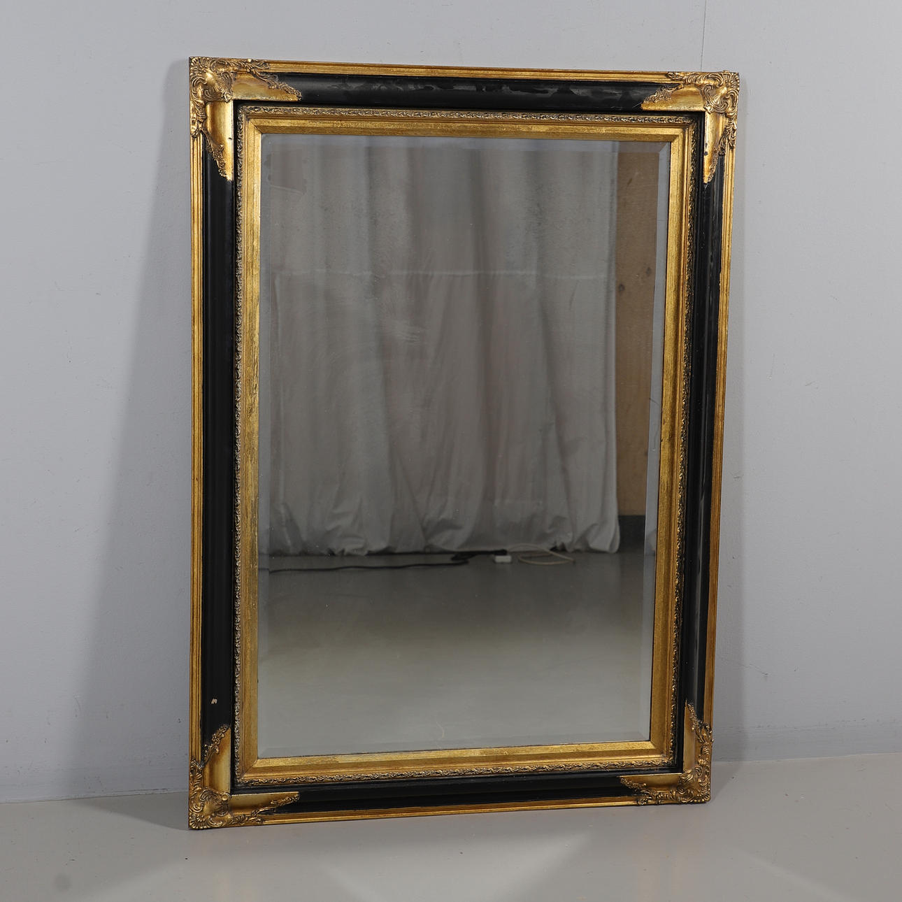 A MODERN GILT PAINTED & EBONISED WALL MIRROR.