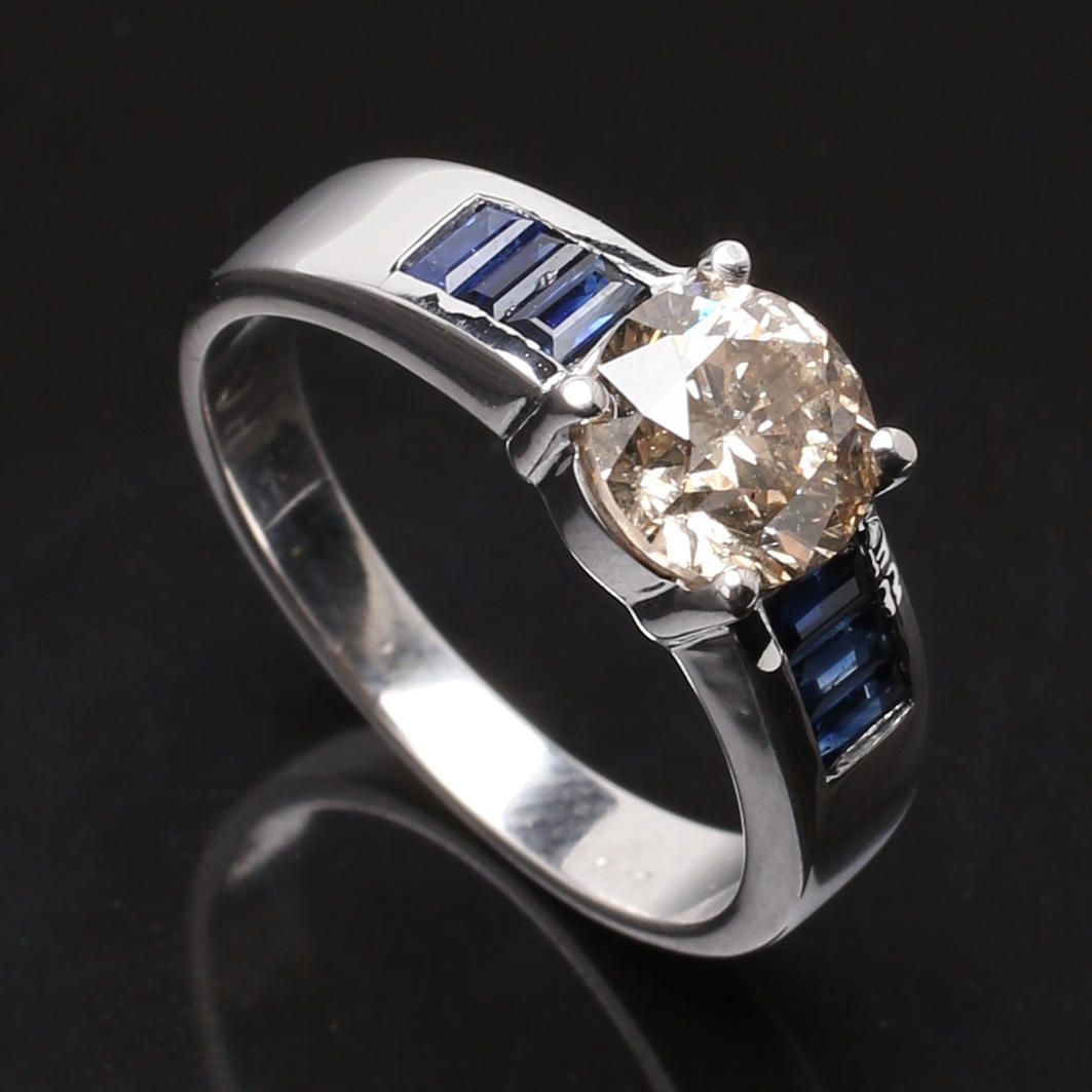 RING i 14 K vitguld med diamanter, blå samt light brown, totalt 1,20 ct.
