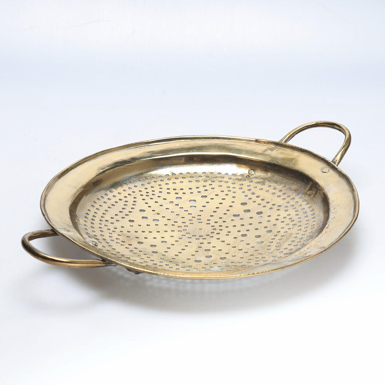 A 17th/19th century brass colander.