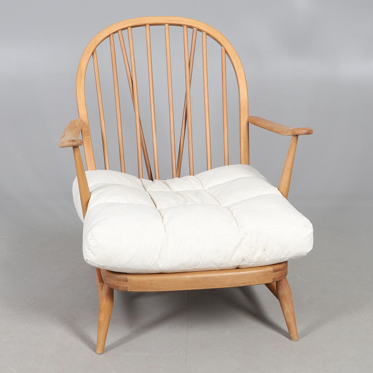 AN ERCOL SPINDLE BACK LOUNGE CHAIR.