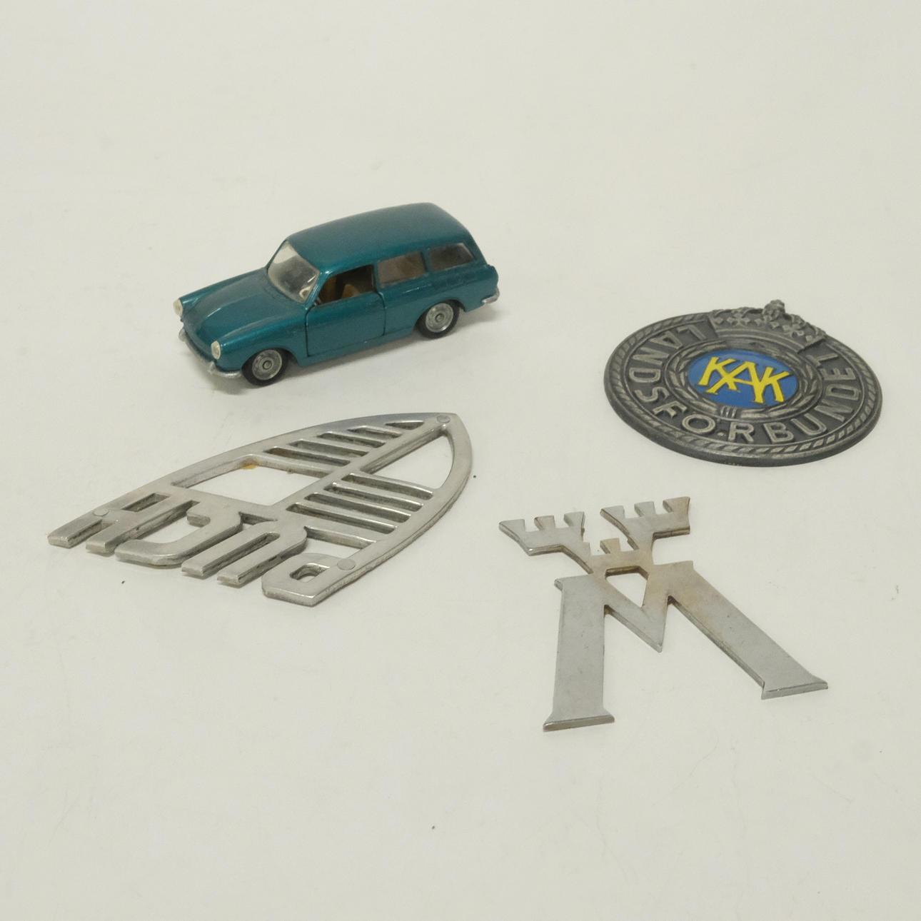 VOLKSWAGEN MODEL CAR AND THREE EMBLEMS.