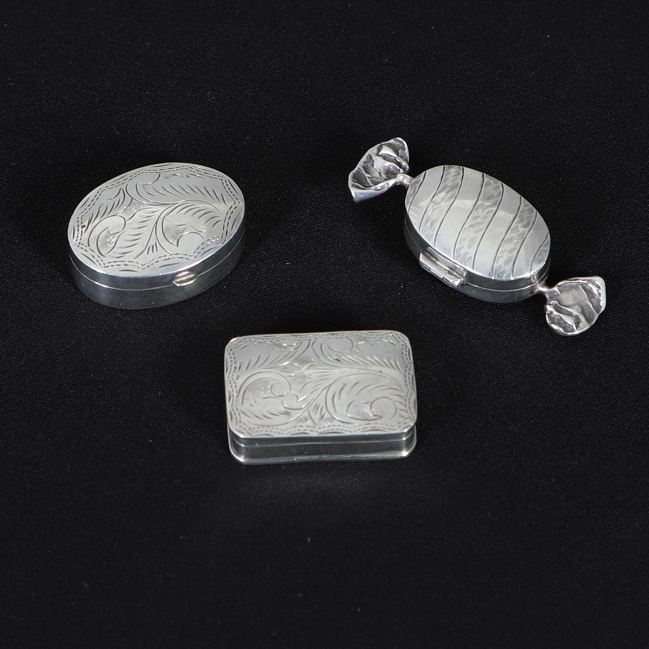 THREE SILVER PILL BOXES.