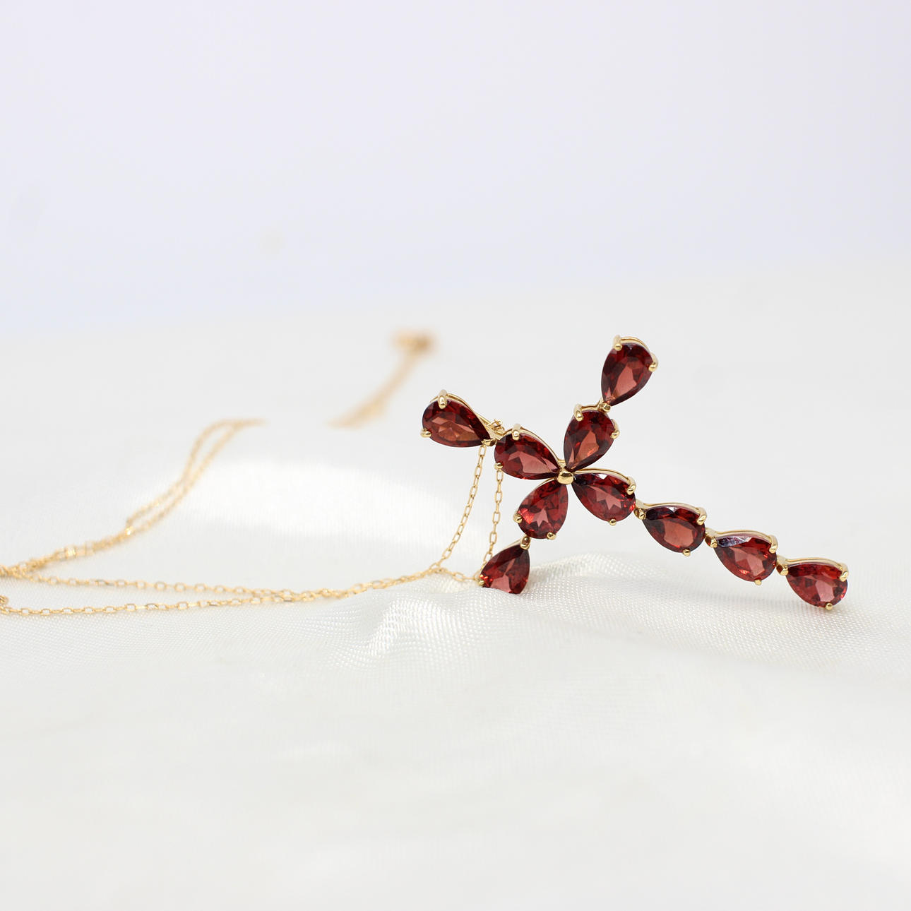 18K GOLD & GARNET CROSS NECKLACE.