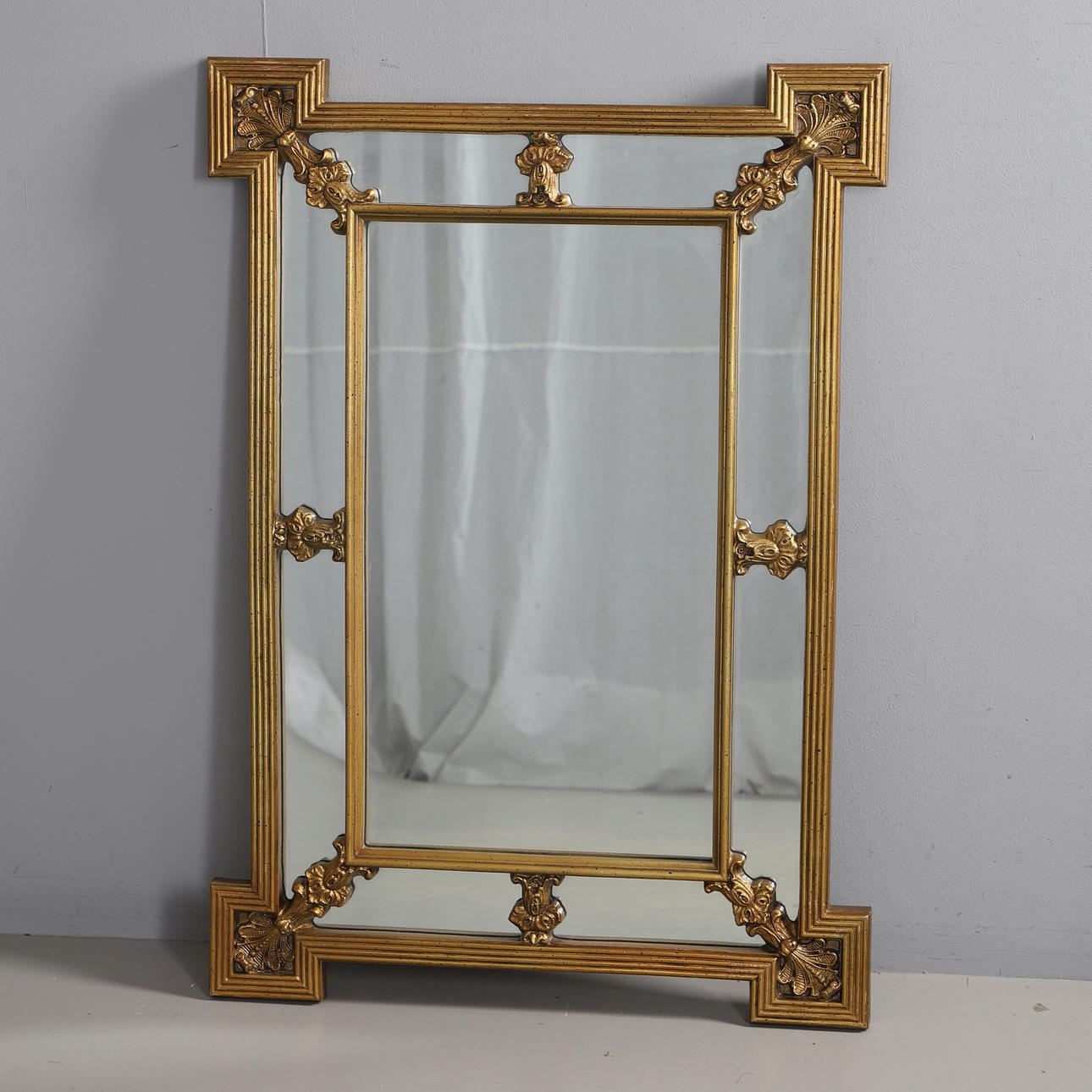 A MODERN GOLD PAINTED SECTIONAL WALL MIRROR.