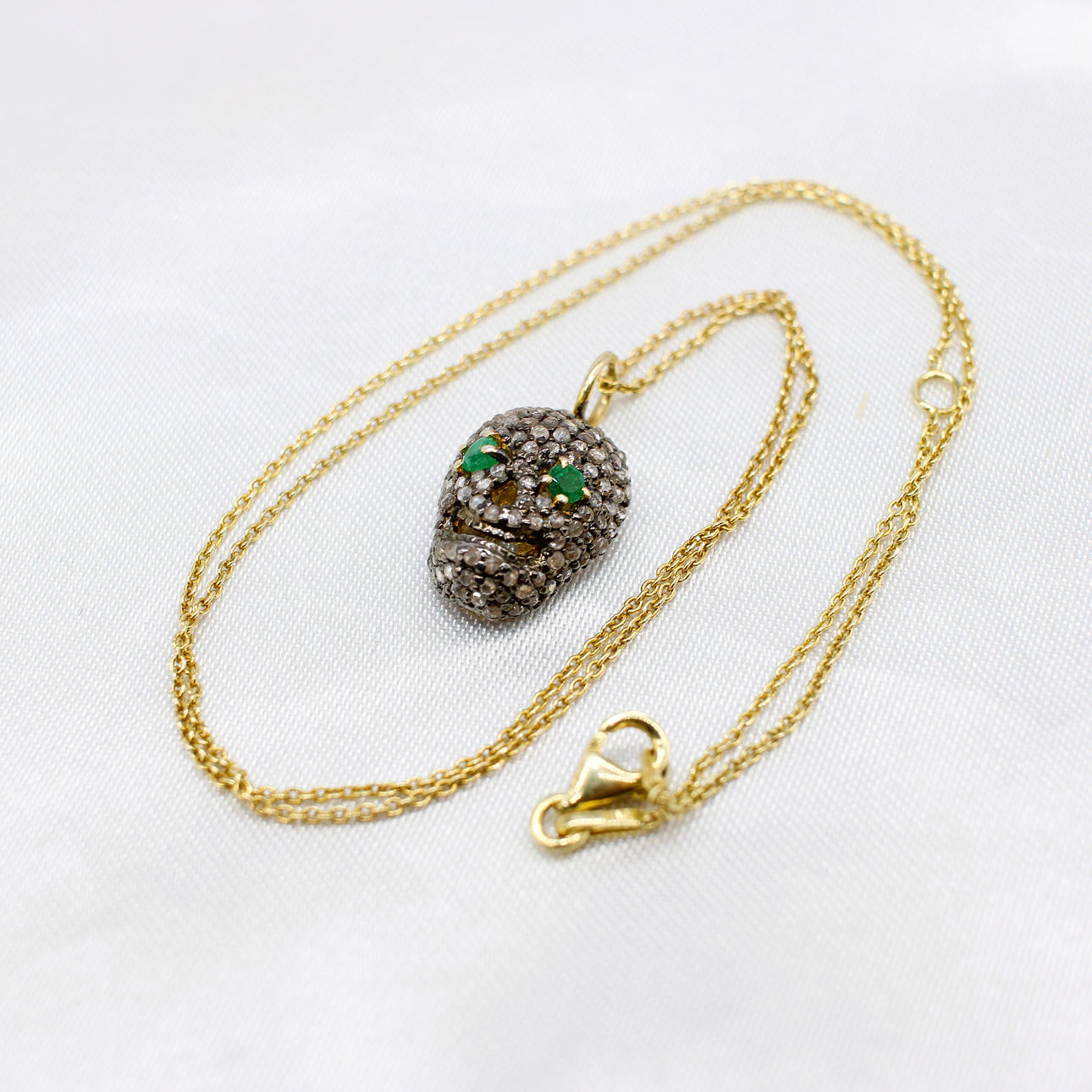 DIAMOND & EMERALD SKULL PENDANT.