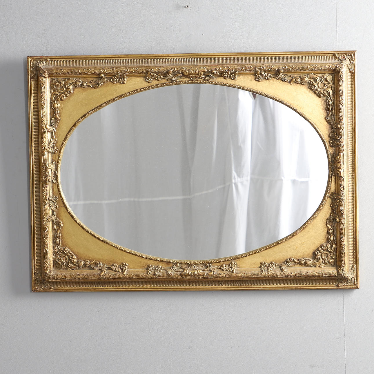 A MODERN GILT FRAMED WALL MIRROR.