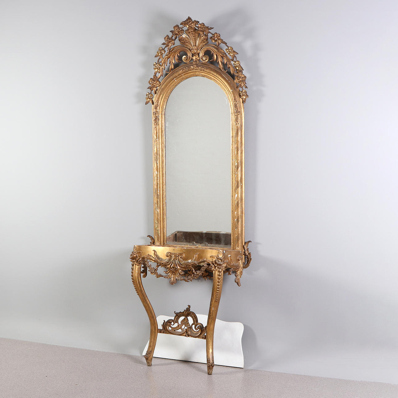 MIRROR WITH CONSOLE TABLE. Bronzed wood and composition, the console table with marble top, Neo-Rococo, second half of the 19th century.