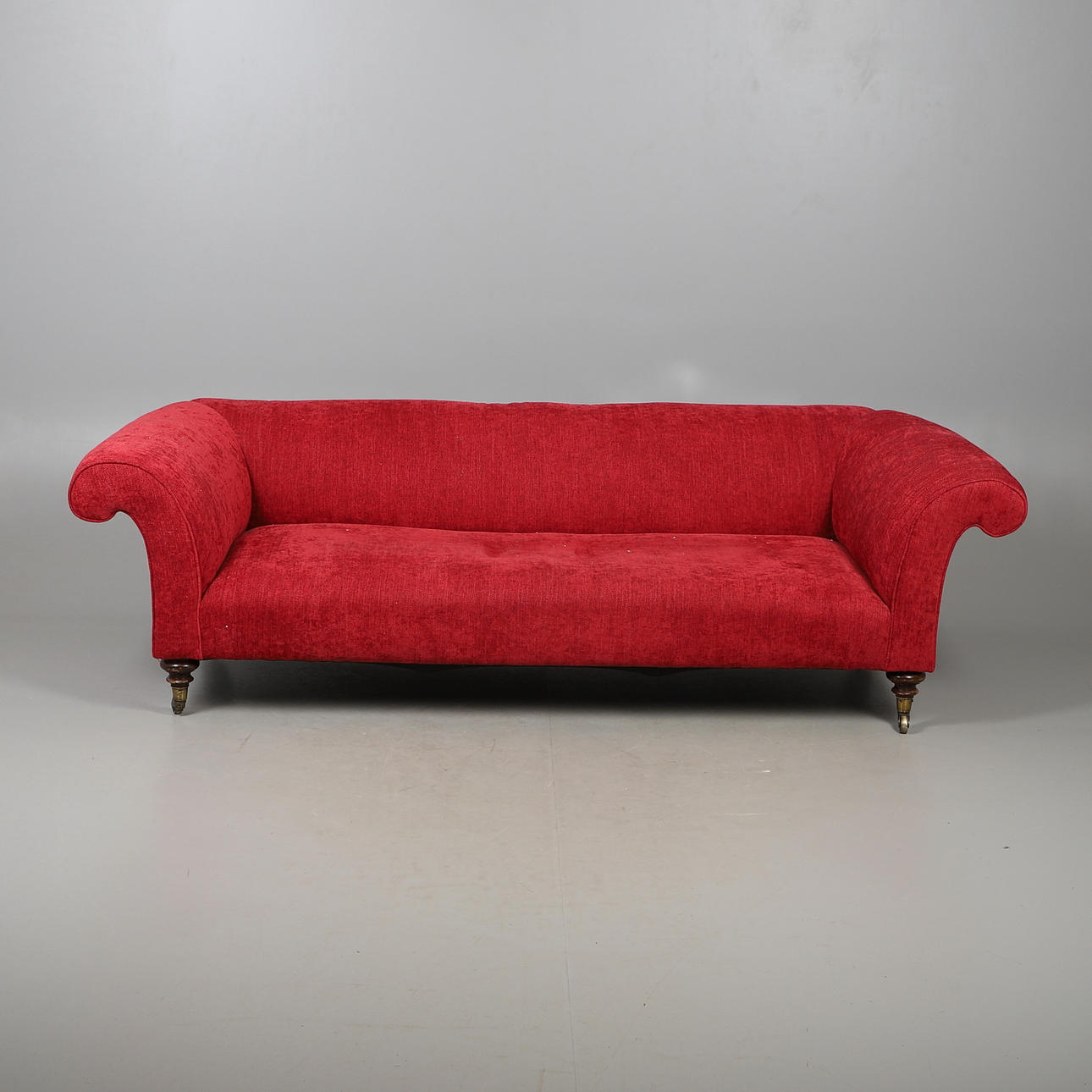 A LARGE RED VELOUR CHESTERFIELD.