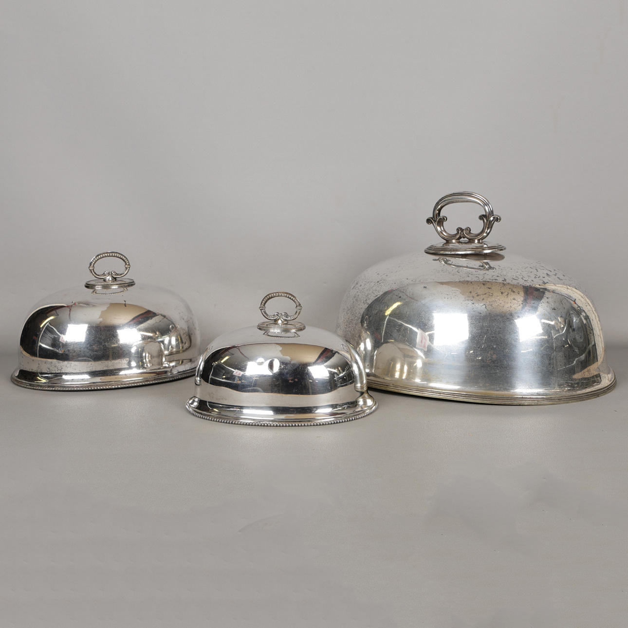 THREE SILVER PLATED MEAT PLATE COVERS (3).