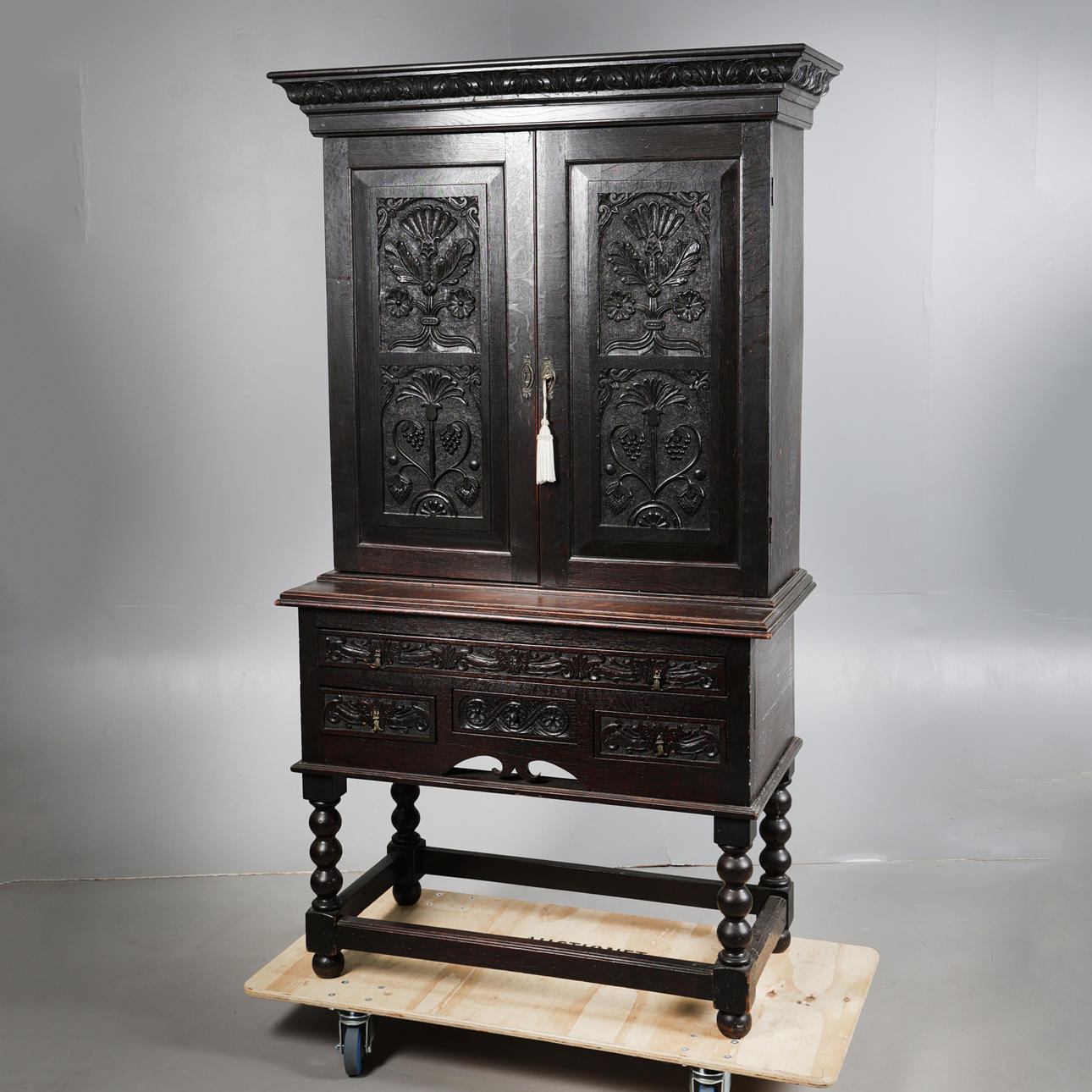 A VICTORIAN OAK CUPBOARD ON STAND.