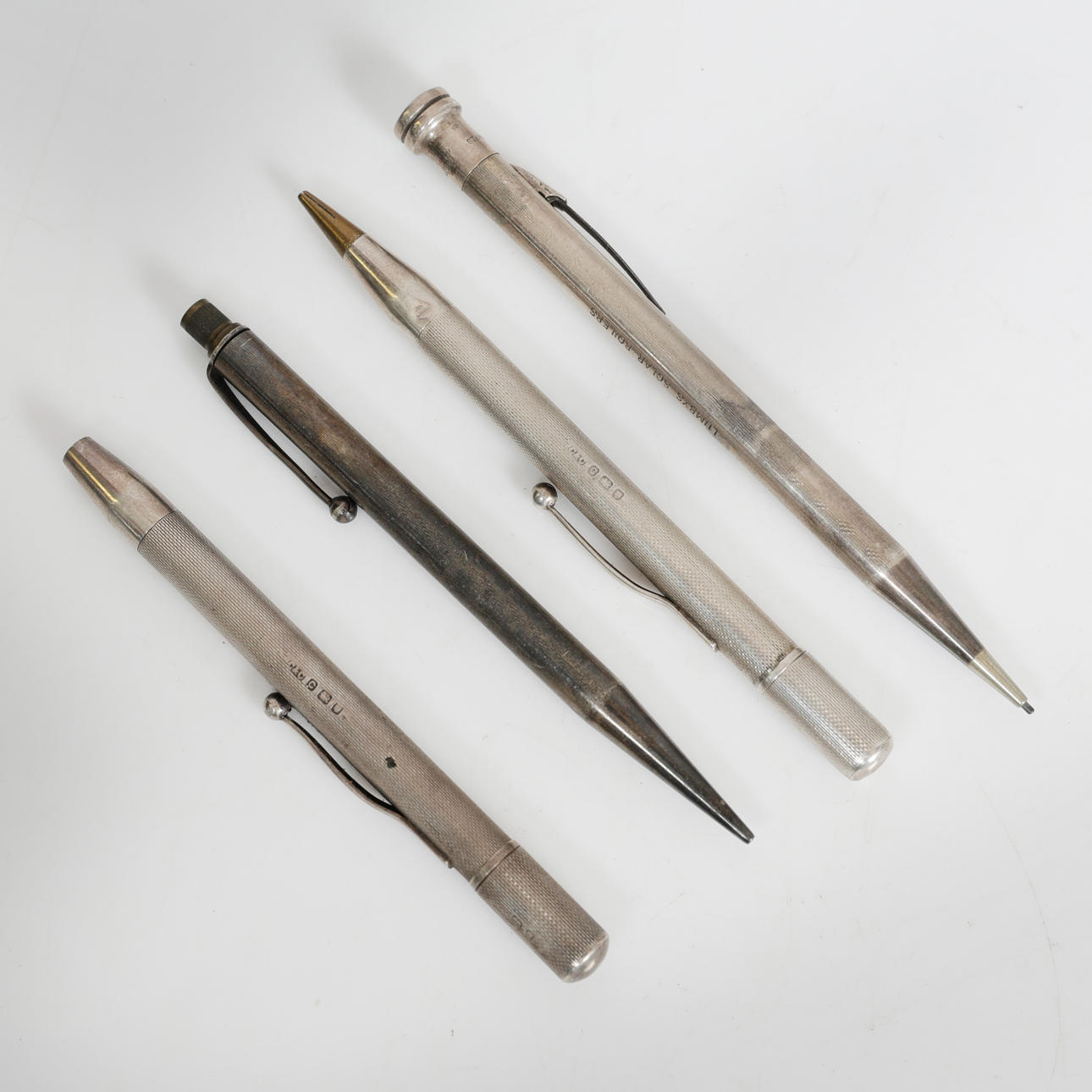 FOUR SILVER PROPELLING PENCILS (4).