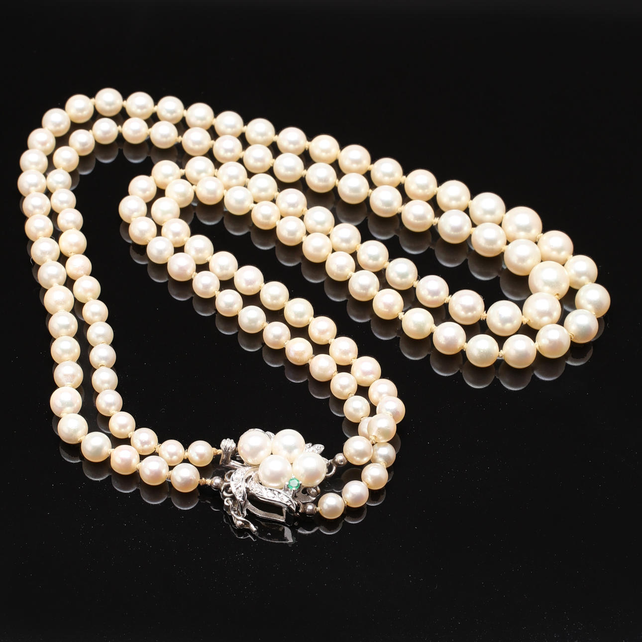 COLLIER, dubbelradigt av akoyapärlor med lås i 18k vitguld med smaragd och diamanter 0 ,15 ct.