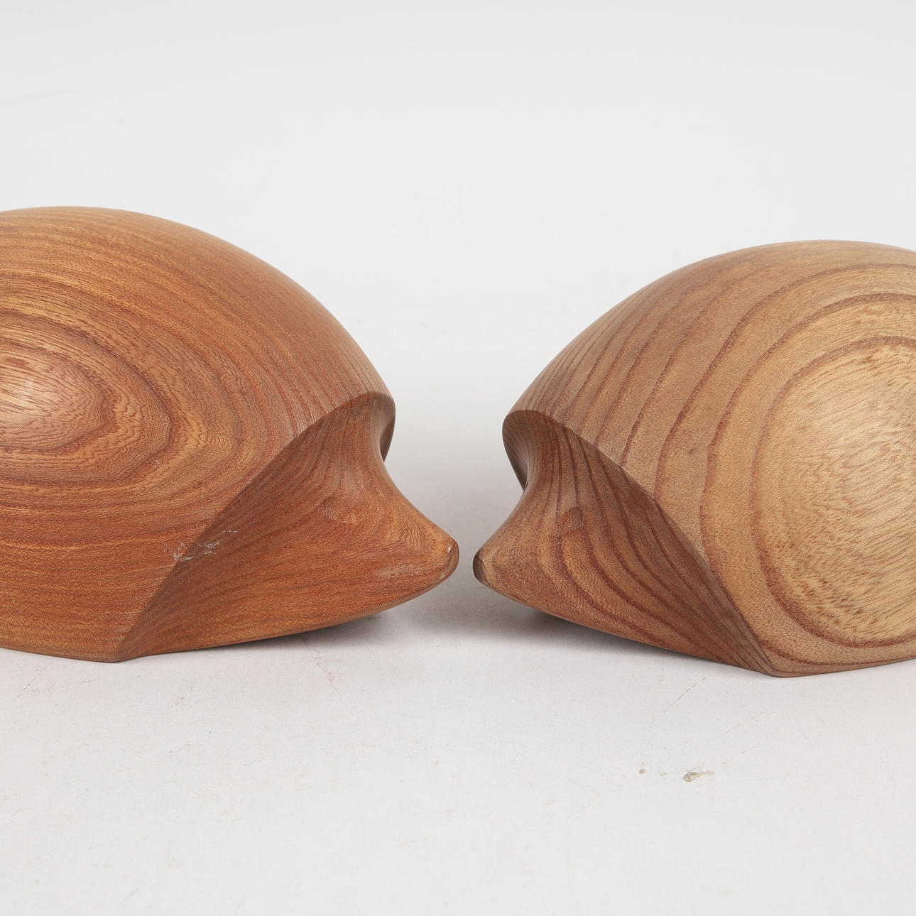 HEDGEHOGS, a pair, teak, incised signature E.K -16.