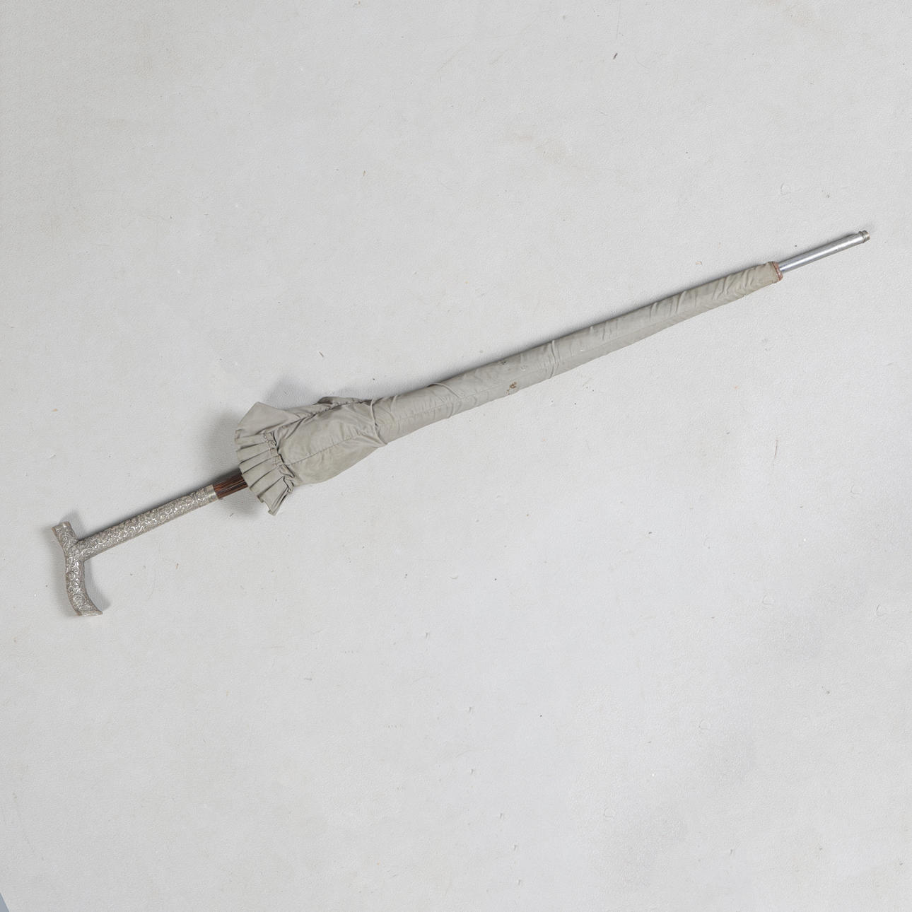 A WHITE METAL HANDLED PARASOL.
