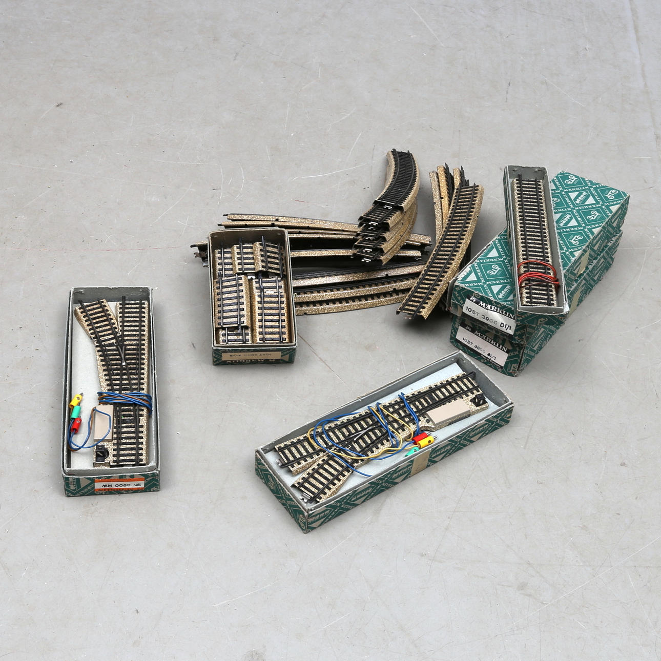 MÄRKLIN modellräls . Bland annat cirka 4 växlar, 16 böjda stora radien, 10 raka , en anslutning och 10 passbitar. Delvis originalkartonger. Model Tracks 3900 and 3800 - Modellgleise 3900 und 3800.